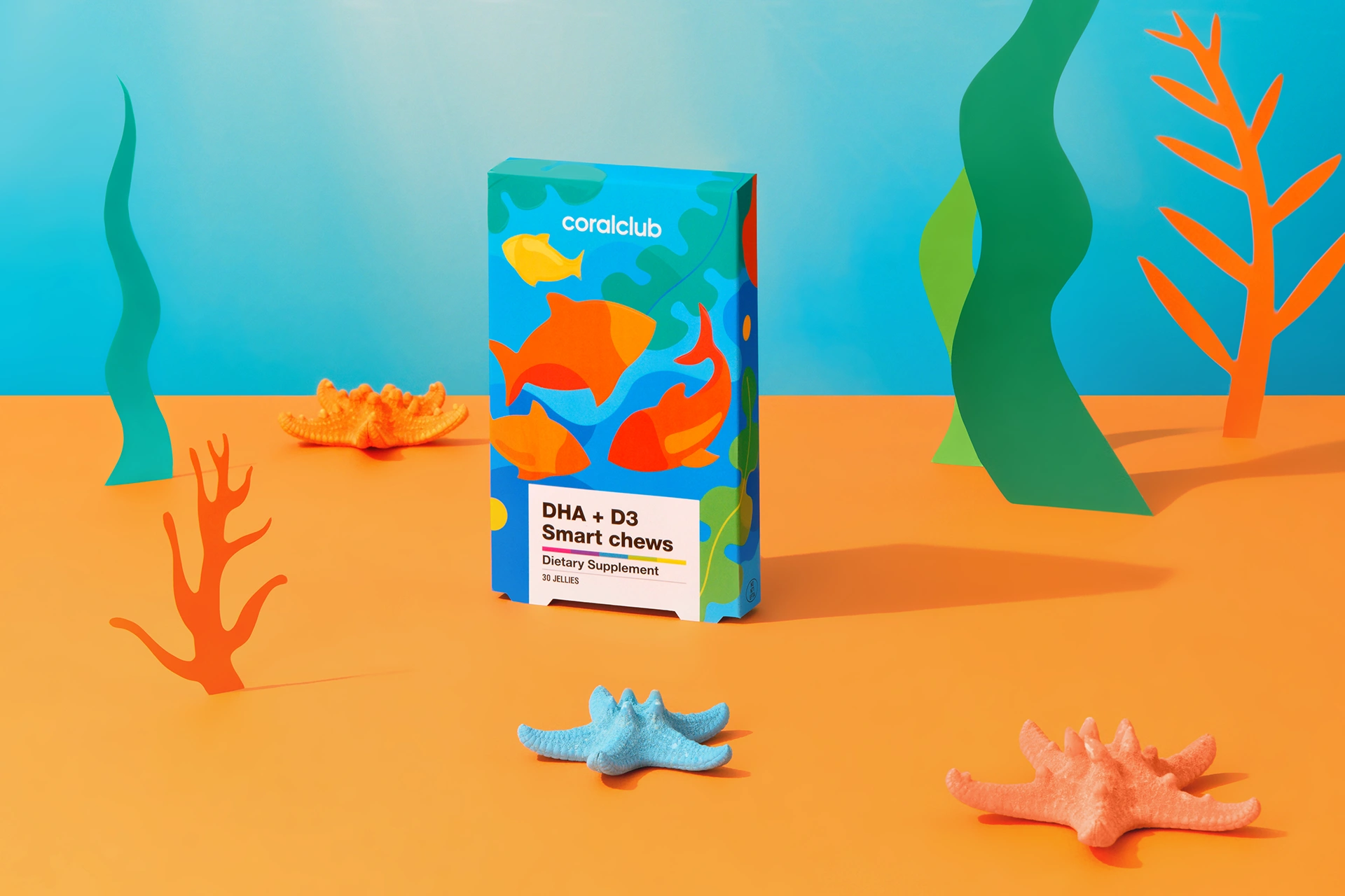 A DHA+D3 Smart Chews pastille surrounded by fresh citrus and children's books